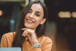 close up portrait of laughing beautiful woman looking at camera in cafe